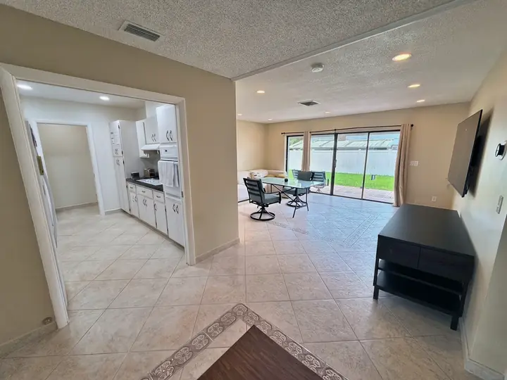 Sala de estar e jantar integradas com mesa e portas de correr de vidro