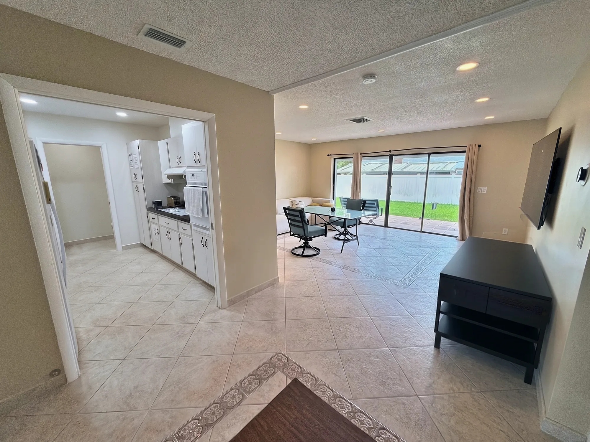 Sala de estar e jantar integradas com espaço para um grupo de 10 na casa de temporada em Hallandale Beach