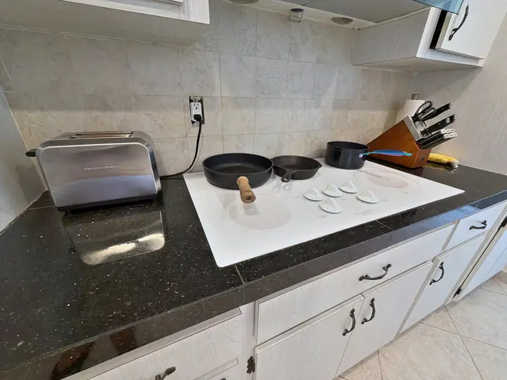 Cooktop da cozinha com panelas, frigideiras e torradeira prontos para usar