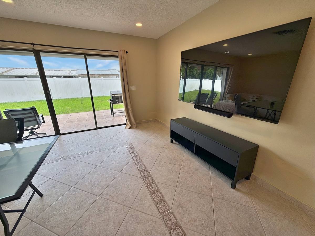 Large wall-mounted TV and patio doors in the living room
